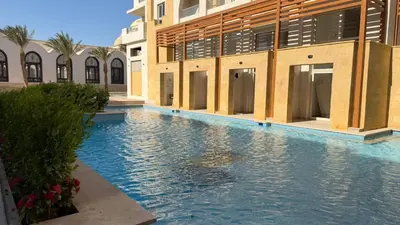 a swimming pool in front of a building at Kuba luxury loft in Hurghada