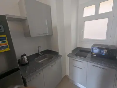 a small kitchen with a sink and a window at Magawish Studio #3 with pool view in Hurghada