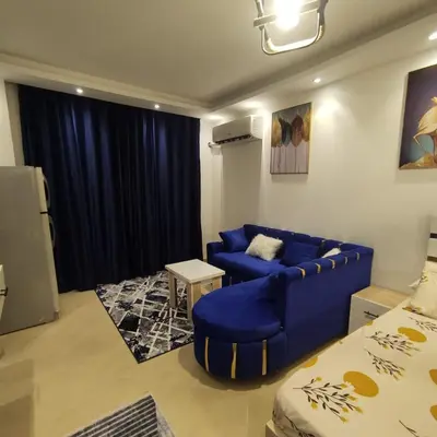 a living room with a blue couch and a table at Florenze J113 Hurghada in Hurghada