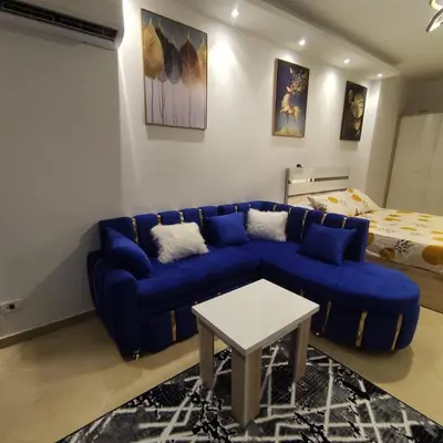 a living room with a blue couch and a bed at Florenze J113 Hurghada in Hurghada