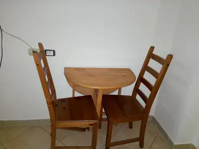 a wooden table and two chairs sitting next to a wall at Florenze J113 Hurghada in Hurghada