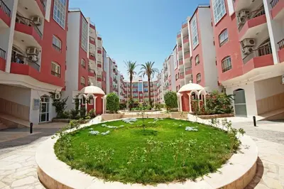 a large building with a grassy area in a courtyard at Desert Pearl Lux in Hurghada
