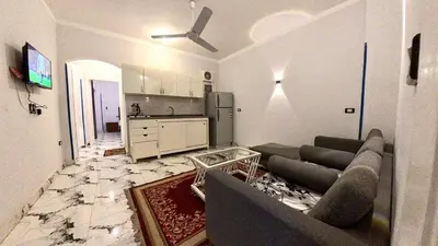 a living room with a couch and a kitchen at Alia House in Luxor