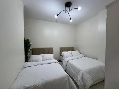 two beds in a room with white walls at Modern Riverside Apartment 3BR in Aswan Downtown in Aswan