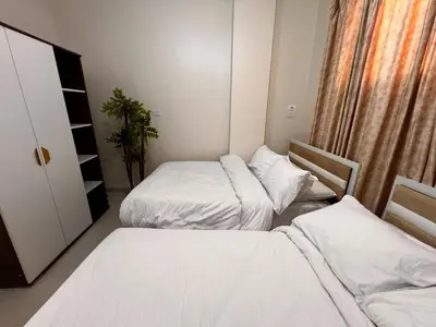 two beds in a small room with white sheets at Modern Riverside Apartment 3BR in Aswan Downtown in Aswan
