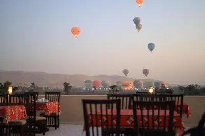 a restaurant with hot air balloons in the sky at Saray ElOmda Wellness - Retreat Village in Al Karnak