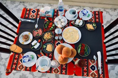 a table with plates of food on top at Saray ElOmda Wellness - Retreat Village in Al Karnak