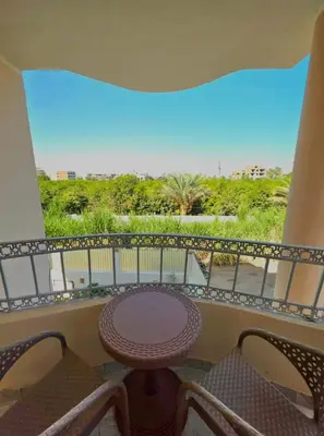 a balcony with a table and chairs and a view at Lokanda lodge&Apartments in Luxor