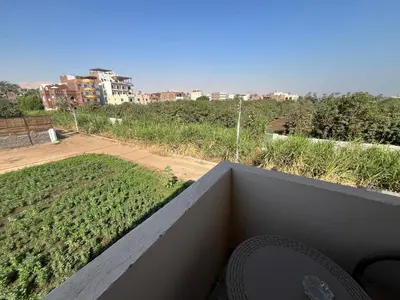 a balcony with a view of a field of plants at Lokanda lodge&Apartments in Luxor