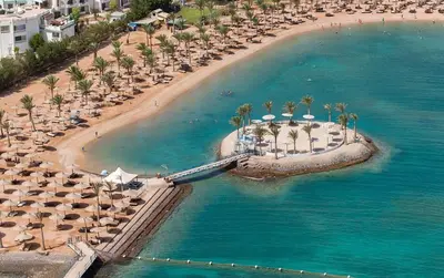 an aerial view of a beach with umbrellas and palm trees at One Bedroom Chalet Mirage Bay in Hurghada