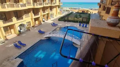 a swimming pool with a bridge in a building at Turtles Beach Resort in Hurghada in Hurghada