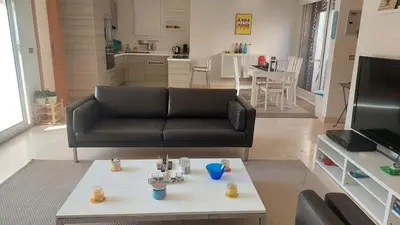 a living room with a black couch and a coffee table at Sunny 2 bedroom retreat - Scarab Club - El Gouna in Hurghada