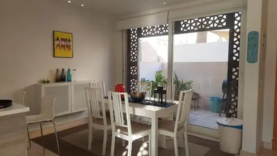 a kitchen and dining room with a white table and chairs at Sunny 2 bedroom retreat - Scarab Club - El Gouna in Hurghada