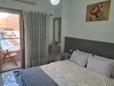 a bedroom with a bed and a balcony at Modern Pool View 1BR with Balcony Prime Location on Hurghada Vibrant Promenade in Hurghada