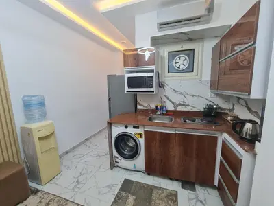 a kitchen with a washing machine and a sink at Modern Pool View 1BR with Balcony Prime Location on Hurghada Vibrant Promenade in Hurghada