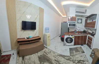 a living room with a tv and a kitchen at Modern Pool View 1BR with Balcony Prime Location on Hurghada Vibrant Promenade in Hurghada