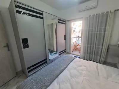 a bedroom with a bed and a large mirror at Modern Pool View 1BR with Balcony Prime Location on Hurghada Vibrant Promenade in Hurghada