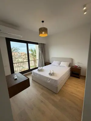 a bedroom with a bed and a large window at Kamaran 2BR Retreat in Hurghada