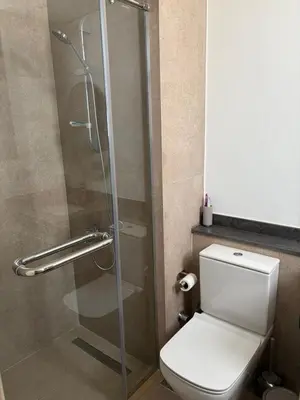 a bathroom with a toilet and a glass shower at Kamaran 2BR Retreat in Hurghada