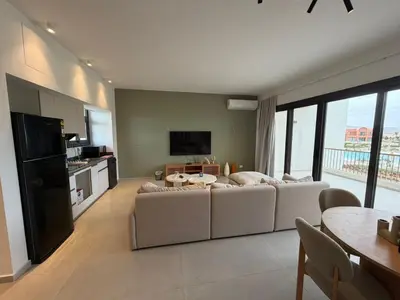 a living room with a white couch and a television at Kamaran 2BR Retreat in Hurghada