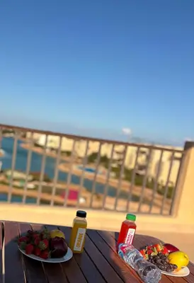a table with two plates of food on a balcony at Chic condo at Tawila 1BR El Gouna in Hurghada