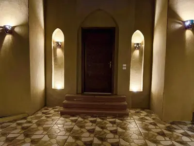 a hallway with a door and stairs in a building at Bab Al Shams Palace in Luxor