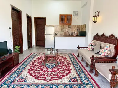 a living room with a couch and a rug at Bab Al Shams Palace in Luxor