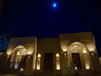 a night view of a building with a moon at Bab Al Shams Palace in Luxor