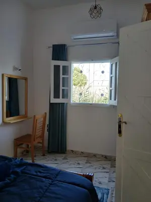 a bedroom with a window and a bed and a chair at Villa Mena Luxor in Luxor