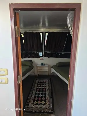 an open door into a tiny house with a bed and couch at The Grand in Aswan