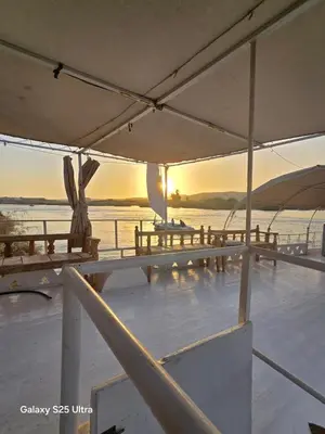 a group of tables on a boat in the water at The Grand in Aswan
