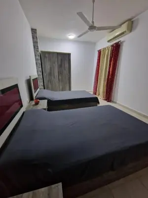 a bedroom with two beds and a window at Kawthar Apartment in Hurghada
