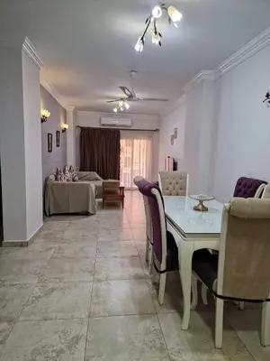 a living room with a table and chairs at Kawthar Apartment in Hurghada