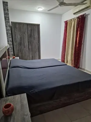 a bedroom with a bed with blue sheets and a window at Kawthar Apartment in Hurghada
