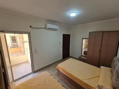 a bedroom with two beds and a sliding glass door at Golden Home Hurghada in Hurghada