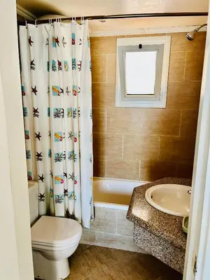 a bathroom with a toilet and a shower curtain at Stylish & Cozy 50 m2 Studio Chalet in the Sunset Pearl Apartments in Hurghada