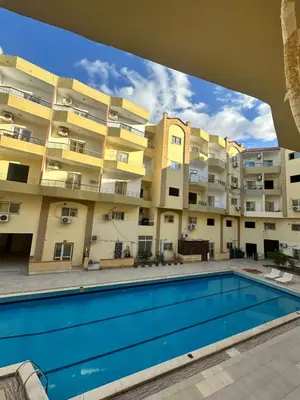 an apartment building with a swimming pool in front of it at Luxury Studio in Hurghada