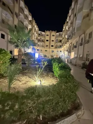 a view of a building at night with palm trees at Luxury Studio in Hurghada