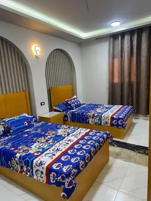 a bedroom with two beds with blue comforters at شقة بالانتر الغردقة in Hurghada