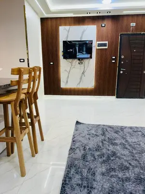 a living room with a tv and a table and chairs at شقة بالانتر الغردقة in Hurghada