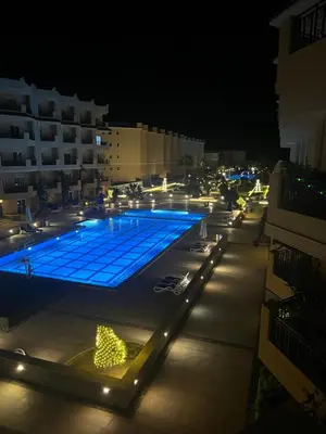 a swimming pool lit up at night with lights at Selena bay hurghada in Hurghada