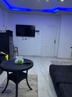 a living room with a table and a tv on a wall at Red Sea view in Hurghada