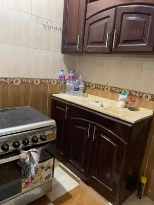 a kitchen with wooden cabinets and a stove top oven at Luxor is adorable! in Luxor