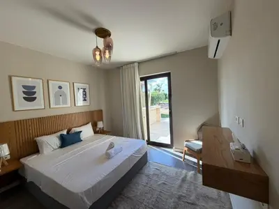 a bedroom with a large bed and a window at Cyan Elegant 3BR Golf View Escape in Hurghada