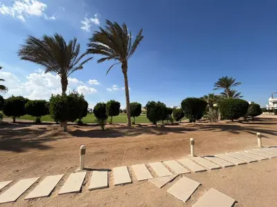 a park with palm trees and a dirt field at Cyan Elegant 3BR Golf View Escape in Hurghada