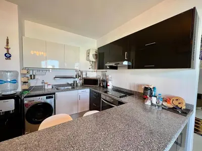 a kitchen with black cabinets and a counter top at Swan Lake 3BR with Roof & Terrace in Hurghada