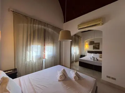 a bedroom with a white bed and a large mirror at Lagoon-Front 3BR Townhouse in Upper Nubia in Hurghada