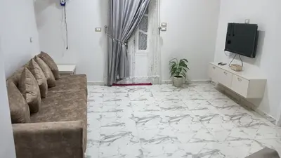 a living room with a couch and a tv at noreno houseاسوان شياخة تانية طريق السادات in Aswan