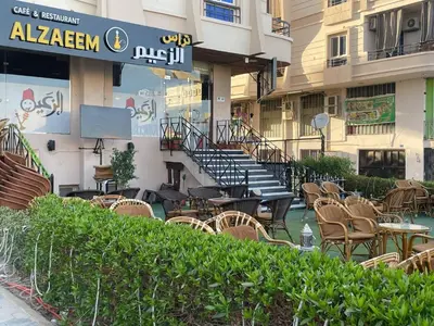 an outdoor patio with chairs and tables and stairs at Paradise at Tiba Al Ahyaa, Hurghada in Hurghada