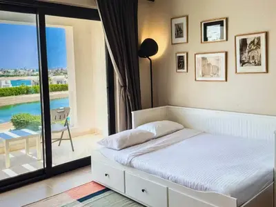 a bedroom with a bed and a view of a pool at View and Location in Abu Tig Marina in Hurghada